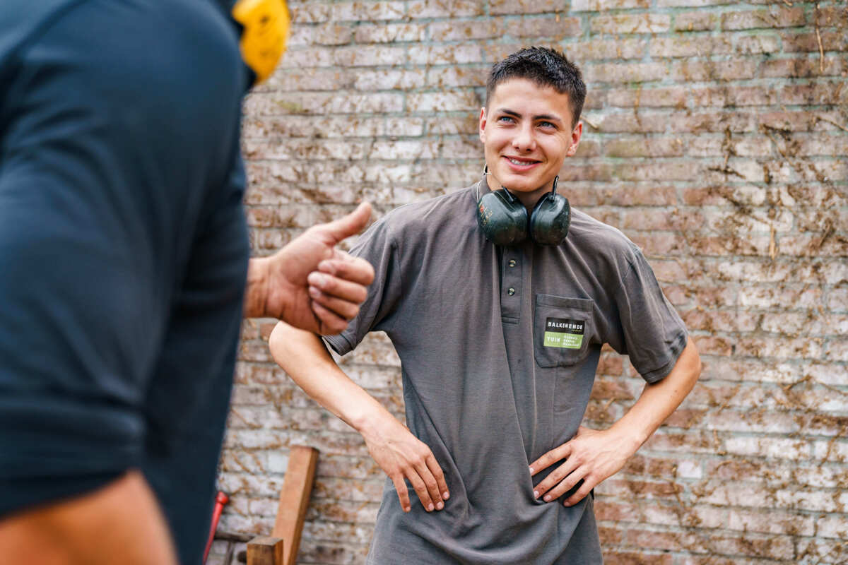 Expert Yvan in tuin met duimopstekende collega